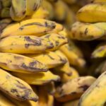 Banane mature su un tavolo, evidenziando il loro colore giallo brillante prima di essere messe in frigo.